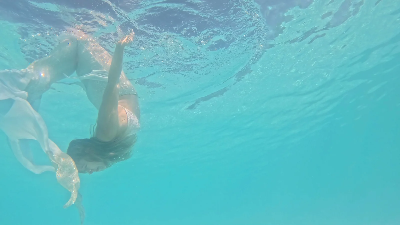 Mermaid bride turning beneath clear turquoise water
